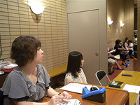 出演者への説明を聞いている受付スタッフ、こんなに至近距離でも気付いていないようです